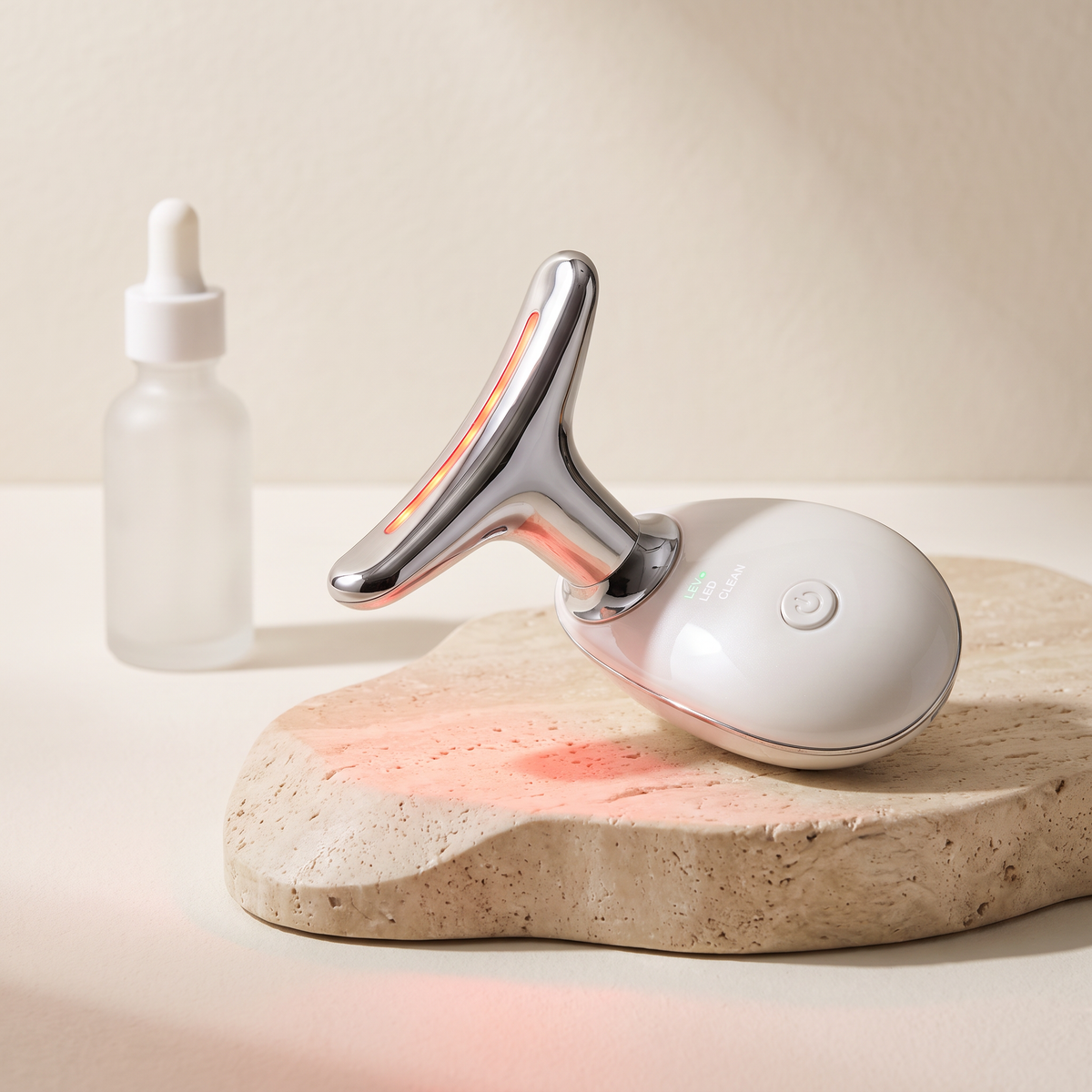 Korvella Sculpt Wand LED neck and face massager with red light on travertine stone